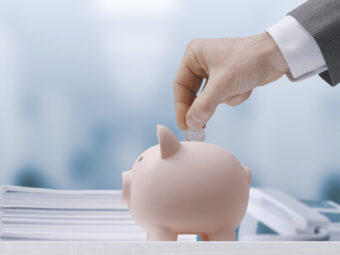 Businessman inserting money in a piggy bank
