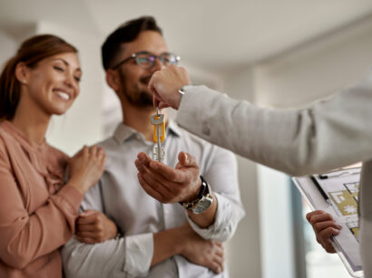 Close-up of real estate agent giving new house keys to a couple.